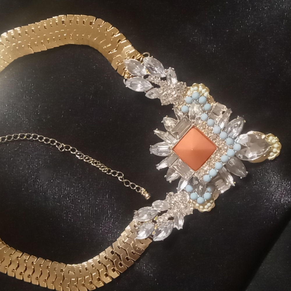 Buckle brand statement necklace with rhinestones in gold tone.